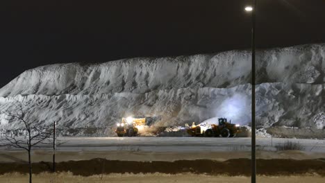 snow plow and front loader machinery clear road and build up snow pile by road