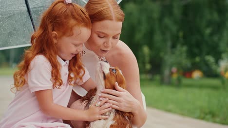 mother, daughter, and dog in the rain