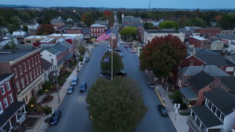 Die-Patriotische-Amerikanische-Flagge-Weht-über-Den-Stadtplatz-In-Anytown,-USA