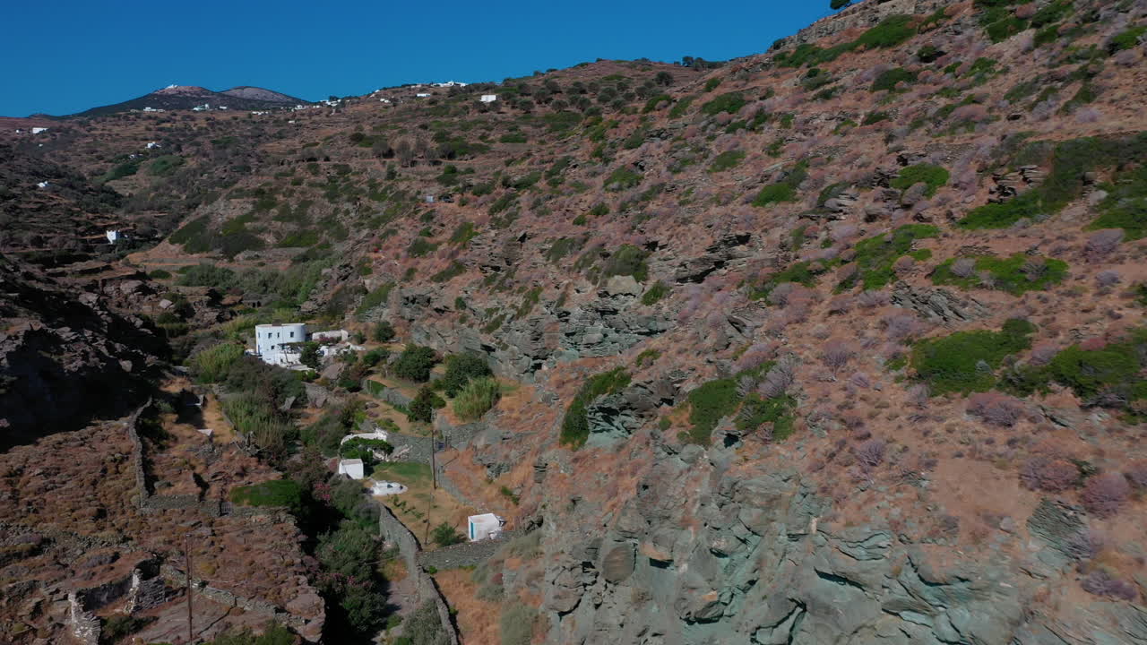 Aerial shot of a classic cycladic landscape, on the Greek island of Sifnos. Camera flies through a gorge.