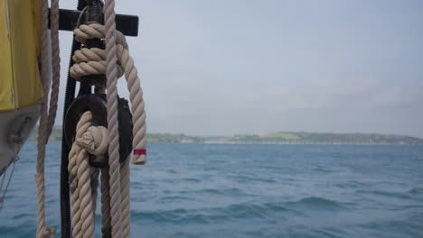 cuerdas y bote salvavidas colgando en el barco con el océano en el fondo