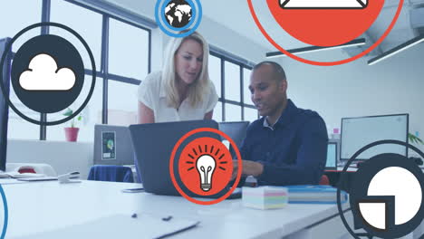 animation of icon in circles over diverse coworkers discussing reports on laptop in office