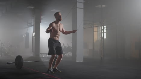 Portrait-of-young-male-athlete-skipping-rope.-Slow-motion-male-athlete-exercising-with-jump-rope-in-a-gym.