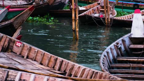 Holzboote-Verschmutzen-Den-Buriganga-Fluss,-Fische-Springen,-Bangladesch,-Asien