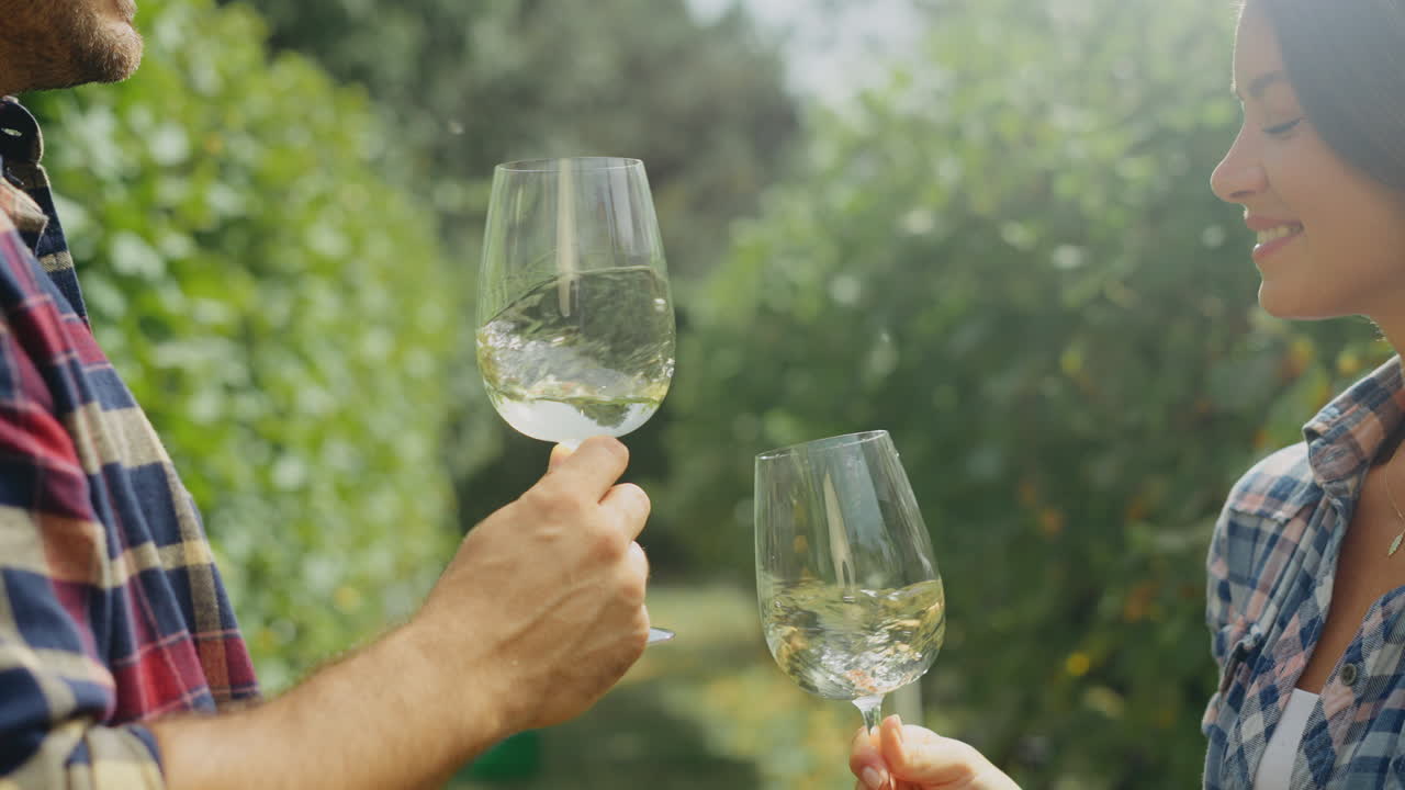 una pareja disfrutando de la degustación de vino en un viñedo