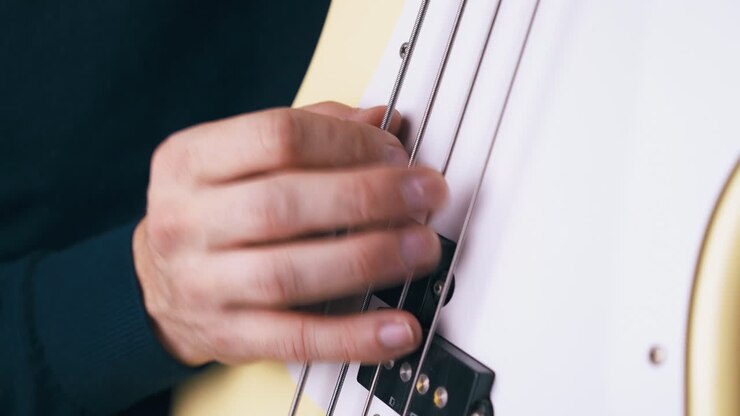il chitarrista esegue la tecnica backbeat sulla chitarra basso