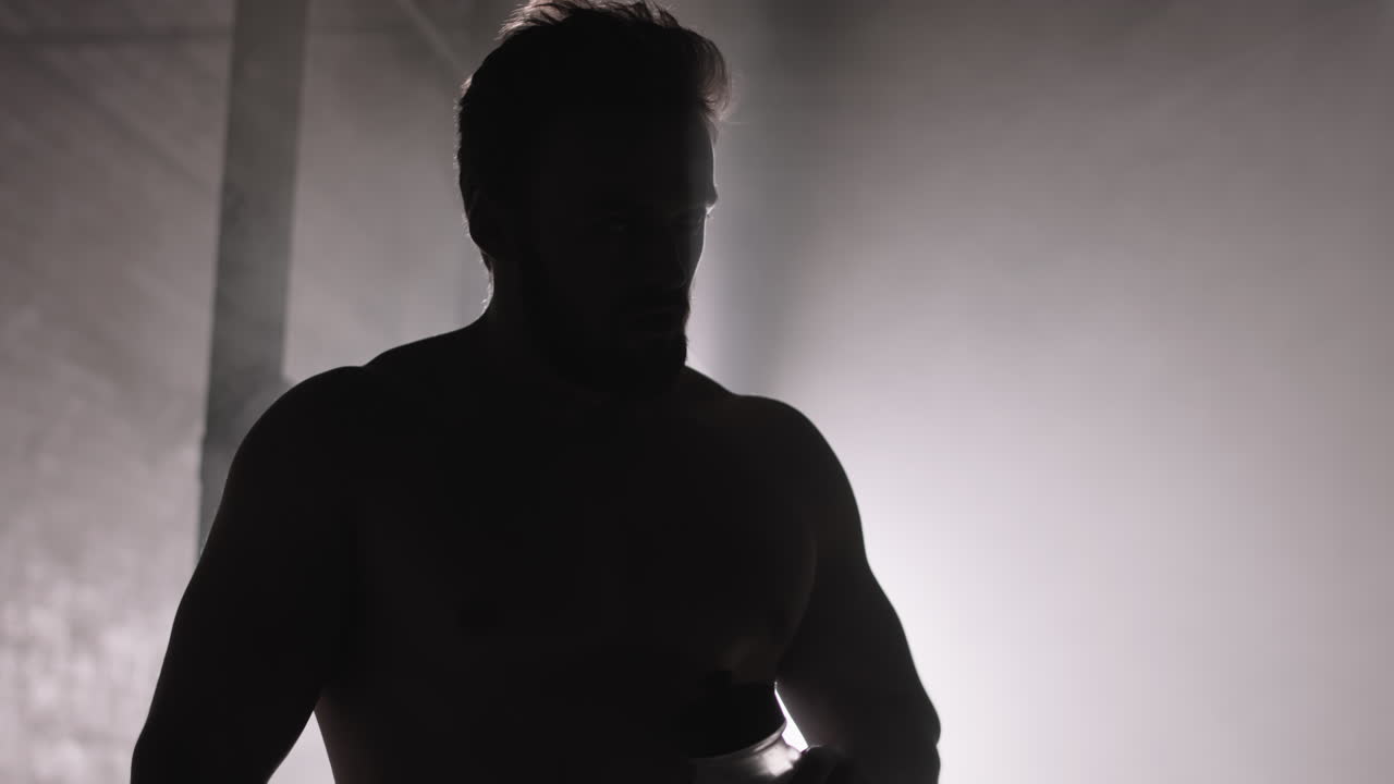 Silhouette of Sportsman Drinking Water after Intensive Training