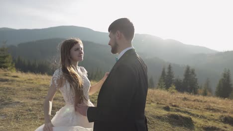 newlyweds. caucasian groom with bride walking on mountain slope. wedding couple