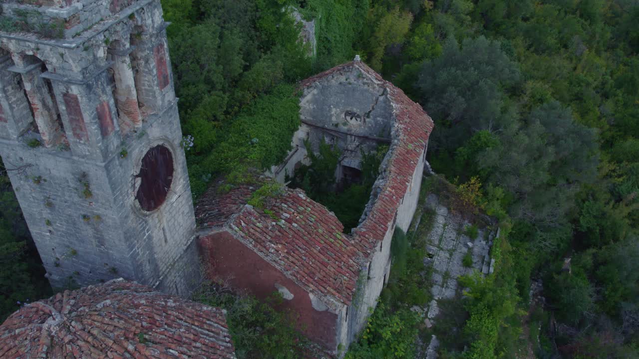 viejas ruinas de la iglesia en medio de una colina verde y exuberante en montenegro, aérea