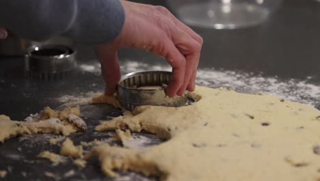 slow motion shot of a baker using a cookie cutter on a scone mixture