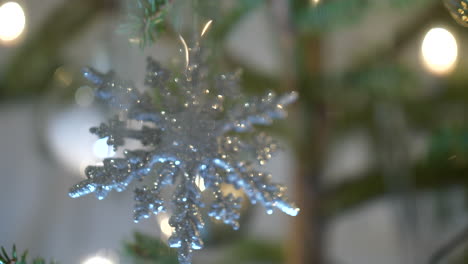 shinning silver snowflake hanging on christmas tree, close up view