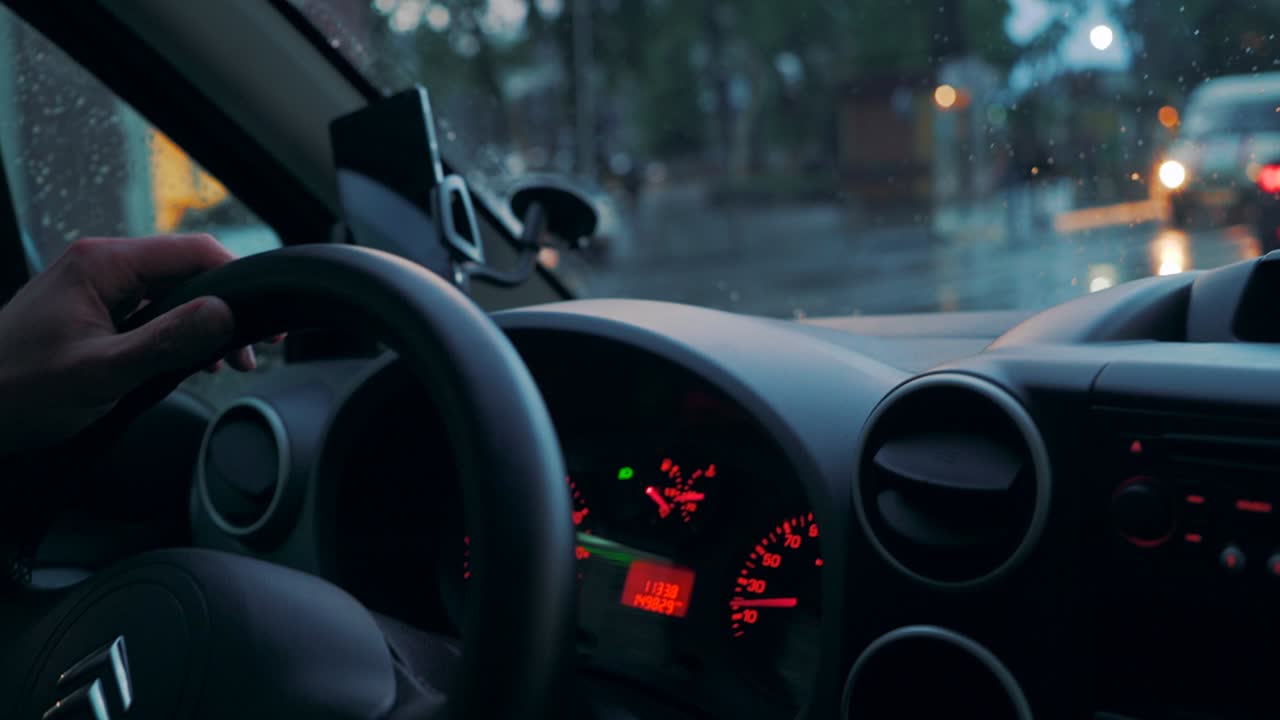 Driving a car in traffic jam in bad weather conditions. Hand of man driving a car. Close-up