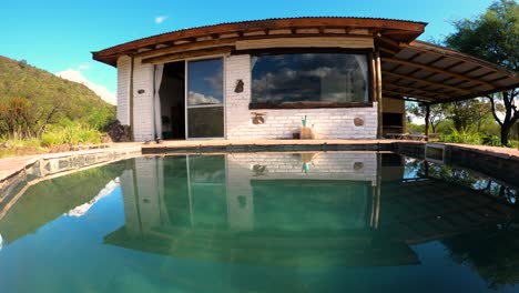 time lapse of small house reflected on swimming pool