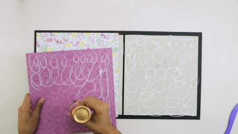 applying liquid glue on decorative paper to create scrapbook cover