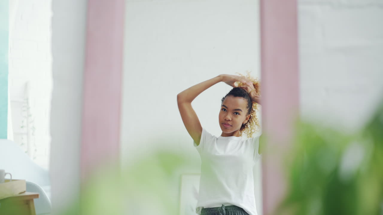 mujer peinando el cabello delante del espejo