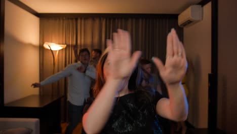 una mujer pobre baila alegremente en una fiesta en un apartamento.