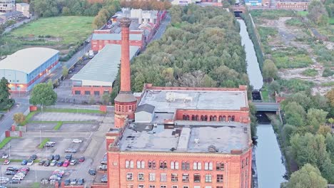 historical industry building next to a small canal in manchester