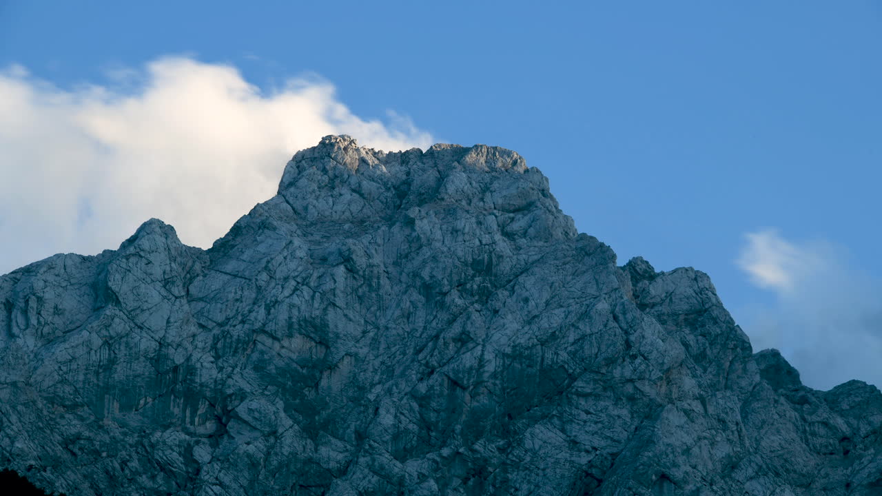 таймлапс облаков над горной вершиной на закате, ойстрица в камниско савиньске альпе, словения, логарска долина, европейские альпы