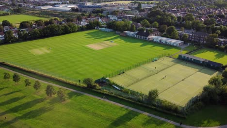 aerial shot flying over a recreational park and sports ground in a british town