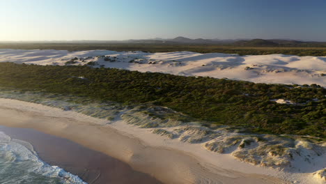 Amplia-Toma-Cinematográfica-De-Drones-De-Las-Dunas-De-Arena-De-Punto-Oscuro-Que-Revelan-La-Playa-Y-El-Océano-En-El-Nido-De-Halcones,-Nueva-Gales-Del-Sur,-Australia