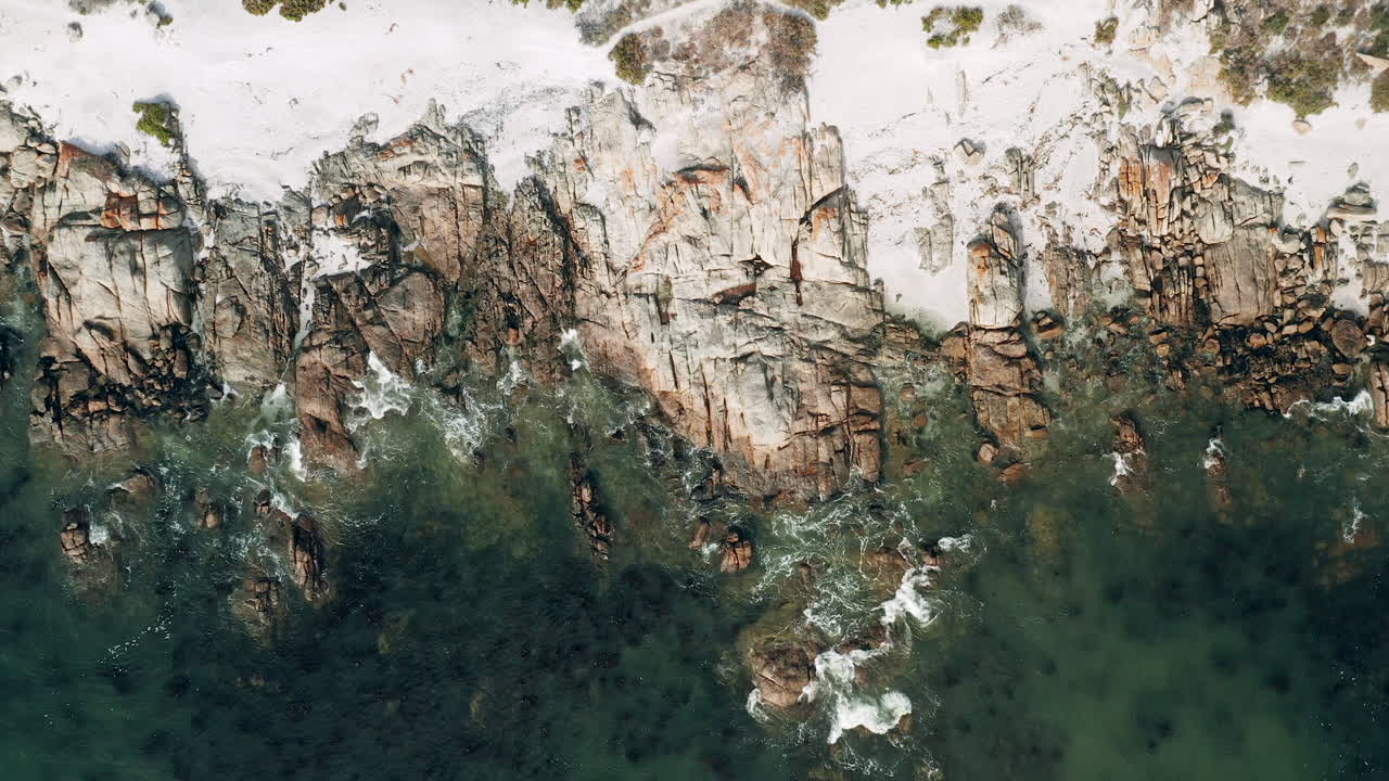 Veduta a volo d'uccello di onde che si infrangono sulla costa rocciosa di Britannia Beach, St