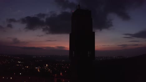silhouette tower at sunset over city