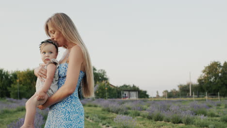 gentle loving mother with her daughter. standing against the backdrop of lavender, in the distance their house