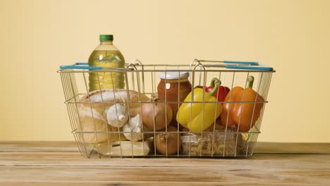 studio shot of basic food items in supermarket wire shopping basket 14