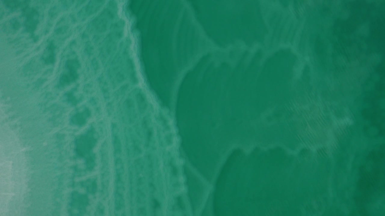 Vista aerea di motivi turchesi e verdi nell'acqua dell'oceano