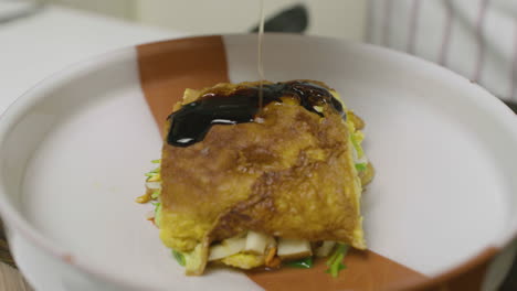 adding sauce and oil onto abalone seafood dish