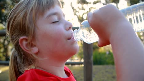 girl drinking water after workout in boot camp