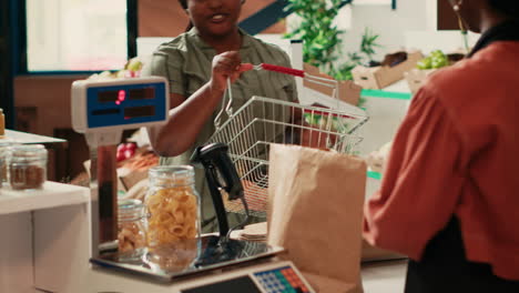 vendor using weighting scale at checkout counter in store