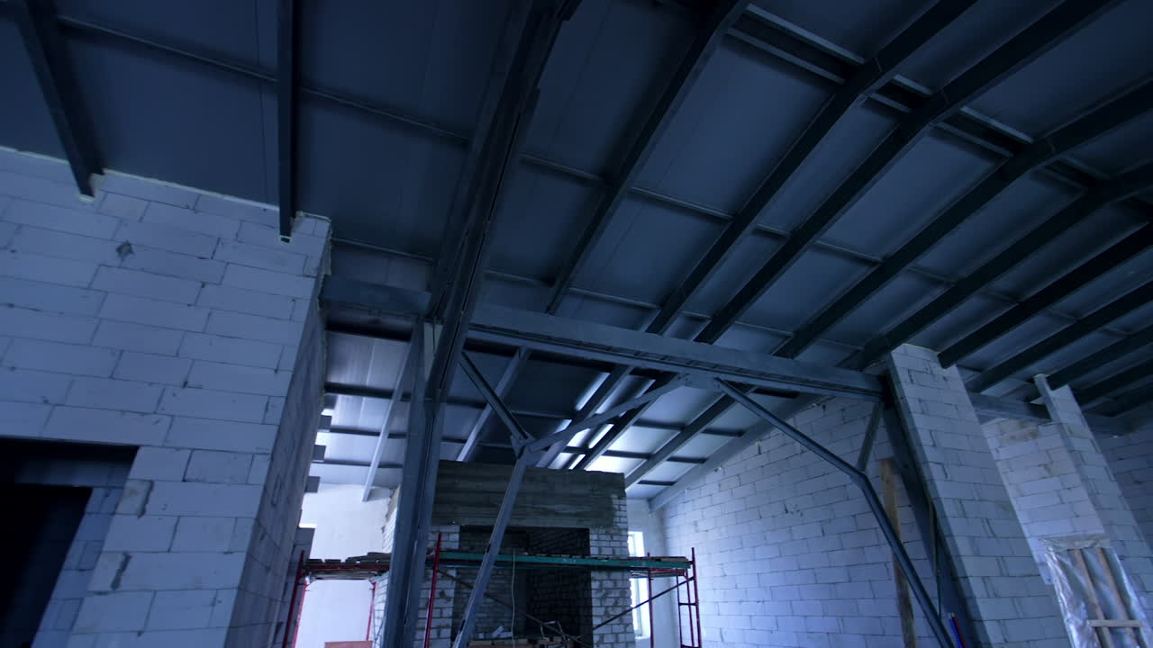 Interior of the premise with white brick walls and metal balks. Low angle view on the new roof.
