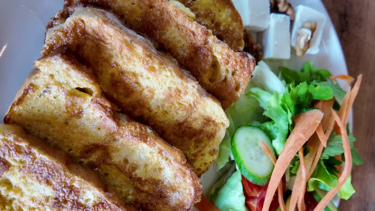 Deliciosos palitos de tostadas francesas servidos con ensalada fresca y queso