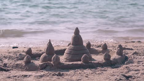 emocionante castillo de arena húmeda con torres y valla en la playa