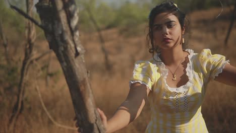 Dreamy-footage-of-a-young-Indian-woman-coyly-looking-down-then-pouting-towards-the-camera-in-afield-outdoors