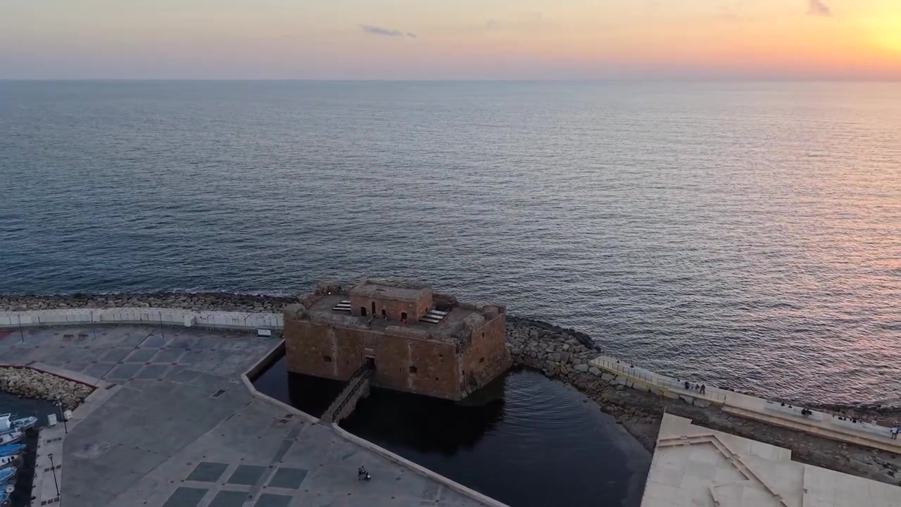 Gün batımında Baf sahil şeridinin ve tarihi kalenin sinematik drone görüntüleri.