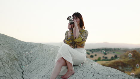 woman on a rock with vintage camera