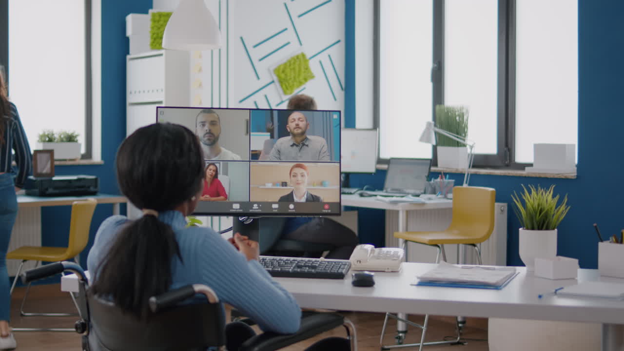 Disabled black manager discussing with remote team using videocall