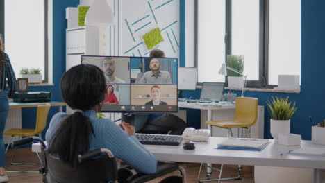 disabled black manager discussing with remote team using videocall