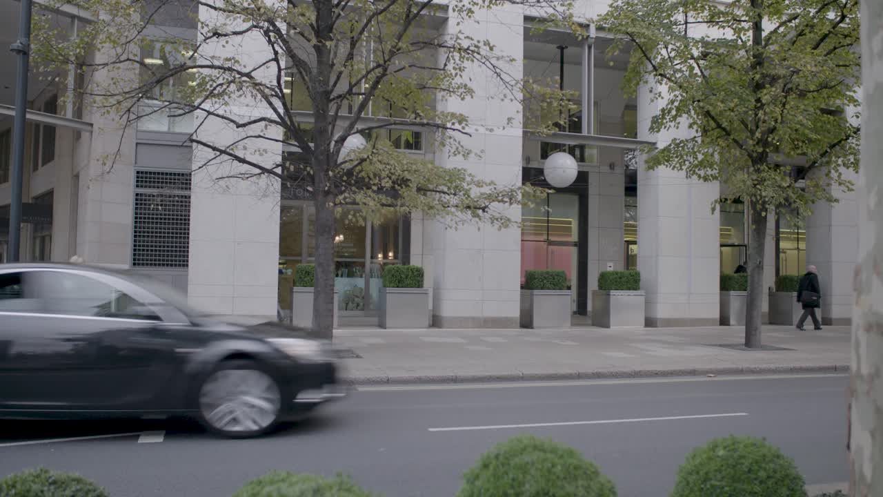 People Walking in Front of a Modern City Building