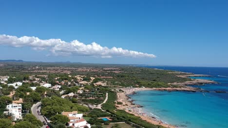 Aerial-shot-of-blue-mediterranean-water-coastline-sandy-beaches-and-beautiful-white-houses-on-a-summer-day-with-blue-sky-and-puffy-clouds