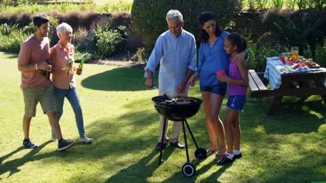 Family-having-beer-while-preparing--barbecue-in-the-park-4k