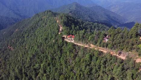 vuelo de avión no tripulado sobre montañas boscosas con carreteras sinuosas en oaxaca