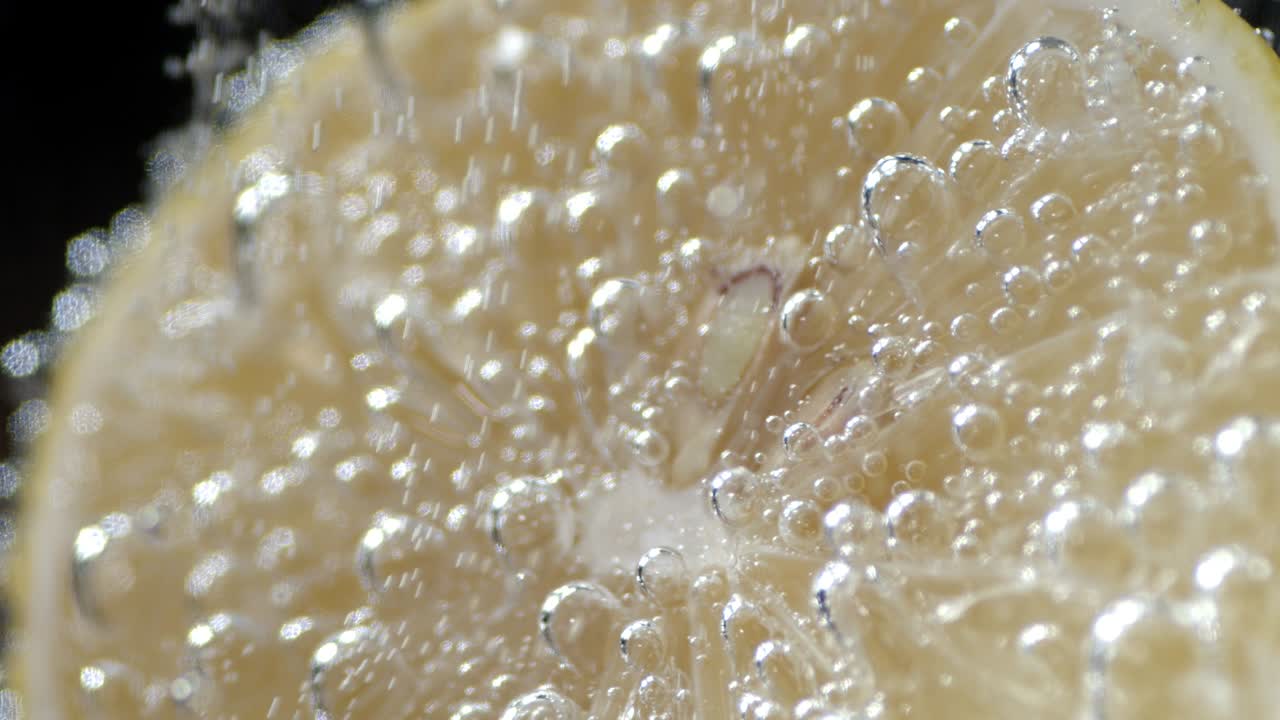 Half of lemon in water with air bubbles.