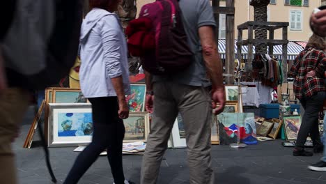 art market at cours saleya in nice with colorful paintings and people browsing