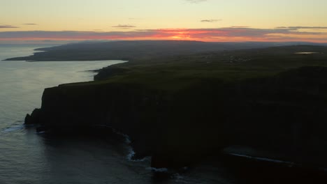 Toma-Aérea-De-Seguimiento-Que-Captura-La-Belleza-De-Un-Amanecer-Sobre-Los-Majestuosos-Acantilados-Del-Norte-De-Moher