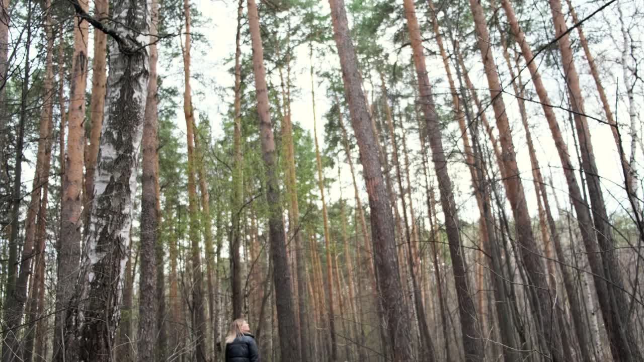 una mujer caminando por un bosque.