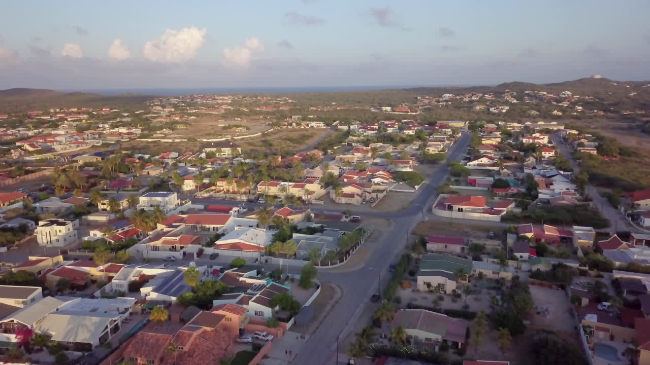 calles y barrio residencial de noord, aruba con el mar azul al fondo