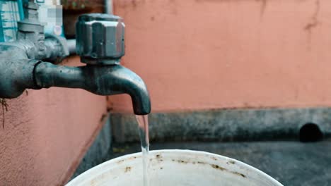 a flowing tap with background showing old wall in the mid day